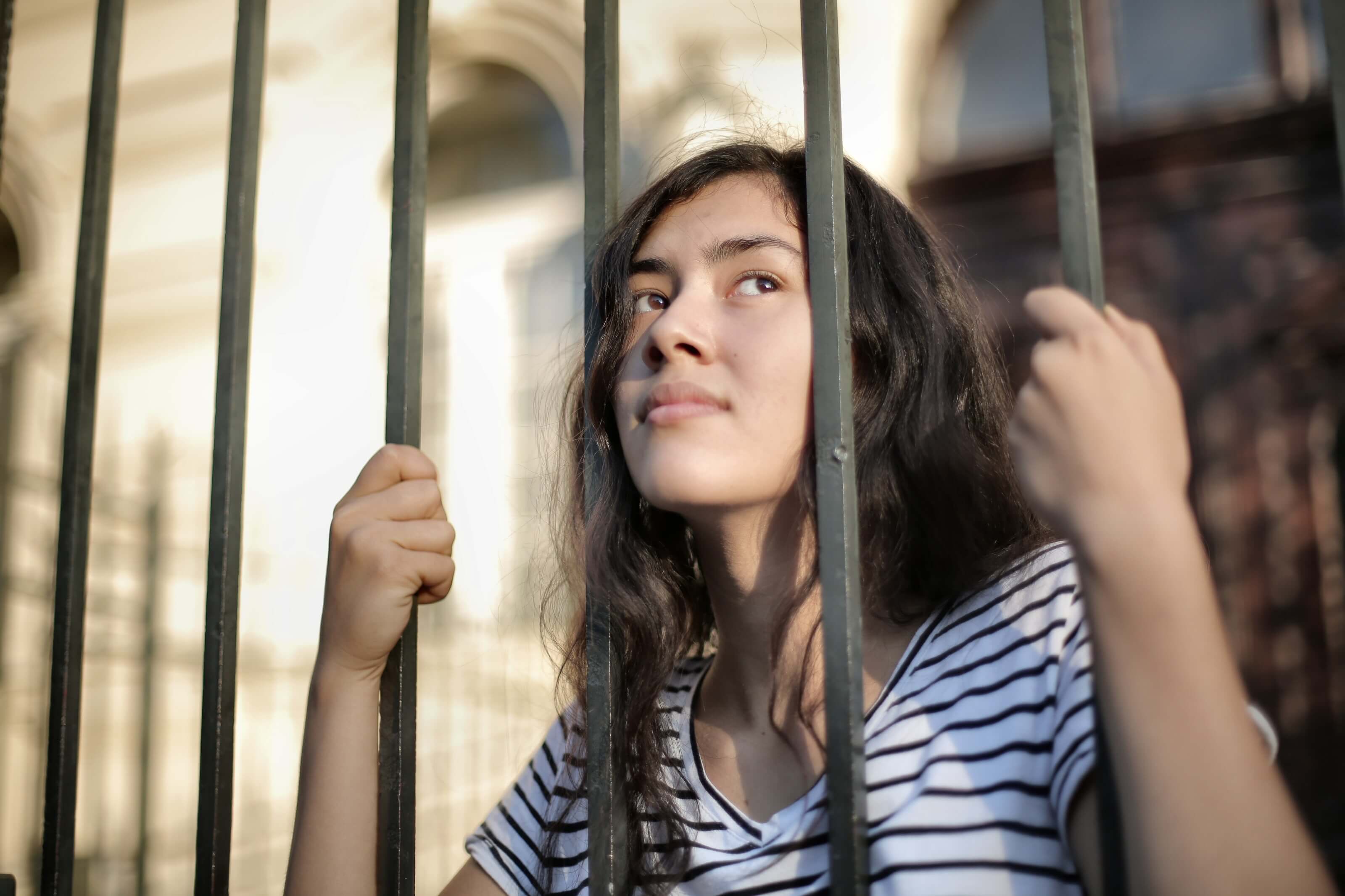 sad-isolated-young-woman-looking-away-through-fence-with-3808803.jpg